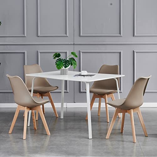 Modern dining table with four chairs and a plant