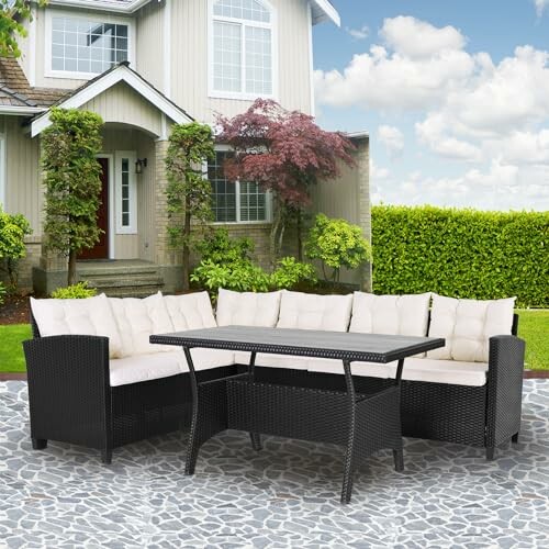 Outdoor patio furniture set with a sectional sofa and table in front of a house.