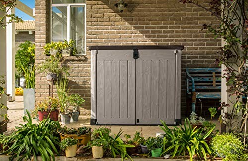 Outdoor storage shed on a patio surrounded by plants.