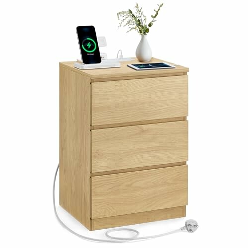 A wooden nightstand with three drawers, charging station, phone, and vase. This is a great example of how the VASAGLE KAILYN Collection can be used in a real-world setting.